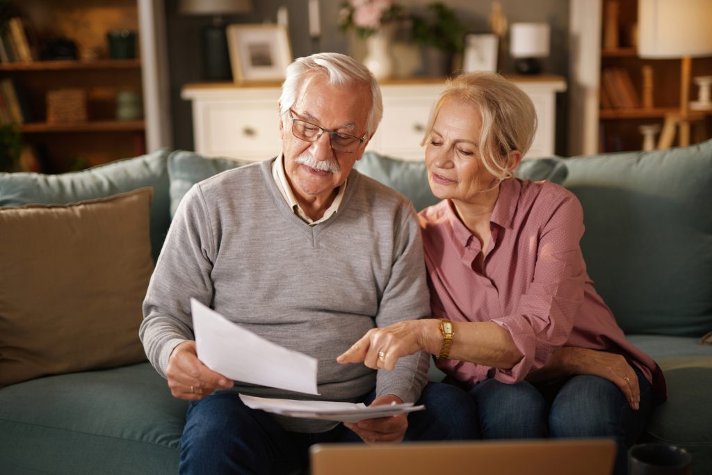 Older couple reviewing legacy planning documents together at home.