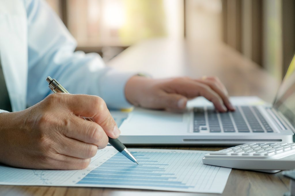 Calculator, laptop, and financial documents used for retirement tax planning.